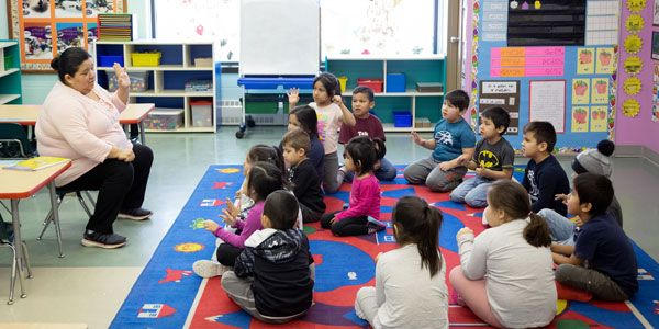 Educator interacting with young children in a kindergarten classroom