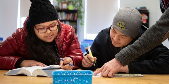 Students receiving individual support from teachers, illustrating the available learning supports